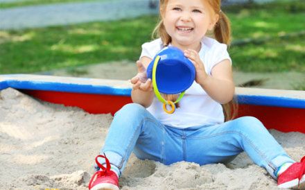 child playing with white play sand